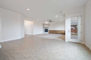 Unfurnished living room featuring a fireplace and ceiling fan