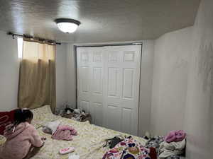 Bedroom with a closet and a textured ceiling