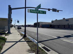 View of road with street lights, curbs, traffic lights, and sidewalks