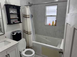 Bathroom featuring toilet, a combined bath / shower with jetted tub, and vanity