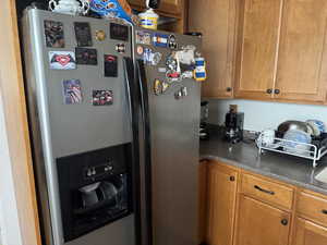 Kitchen with brown cabinets and stainless steel fridge with ice dispenser