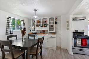 Dining area with light hardwood / wood-style flooring and a textured ceiling