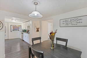 Dining area featuring a textured ceiling and dark wood-type flooring