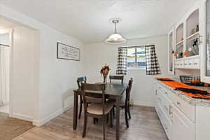 Dining area featuring a textured ceiling and light hardwood / wood-style floors