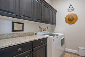 Laundry area featuring cabinets, washer and dryer, and light hardwood / wood-style floors