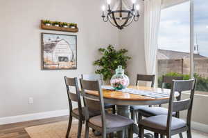 Dining room with hardwood / wood-style floors, a chandelier, and a healthy amount of sunlight