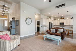 Living room with sink, a high ceiling, and hardwood / wood-style floors