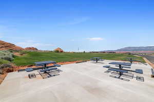 View of property's community featuring a mountain view, a patio, and a lawn