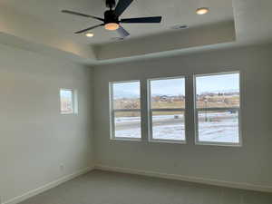 Primary Bedroom with trey ceiling, oversized windows, and ceiling fan.