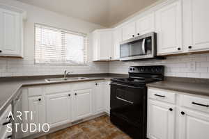 Kitchen featuring white cabinetry, sink, decorative backsplash, and black / electric stove