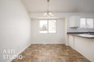 Unfurnished dining area with a chandelier and sink