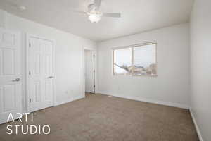 Unfurnished bedroom featuring ceiling fan and carpet