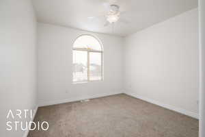 Unfurnished room featuring ceiling fan and carpet flooring