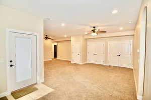 Carpeted empty room featuring ceiling fan