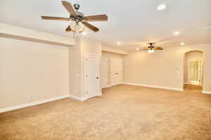 Carpeted spare room featuring ceiling fan