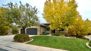 View of front of property with a garage and a front yard