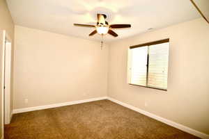 Carpeted spare room with ceiling fan