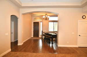 Unfurnished dining area with dark hardwood / wood-style floors and a notable chandelier