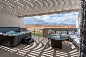 View of patio / terrace with a hot tub, an outdoor living space, a mountain view, and a pergola