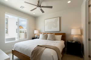 Carpeted bedroom featuring ceiling fan