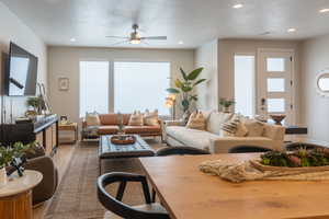 Living room featuring a textured ceiling, hardwood / wood-style flooring, and ceiling fan