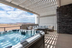 Balcony with a hot tub, an outdoor living space, a pergola, and a mountain view