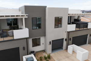 View of front facade featuring central AC unit and a garage