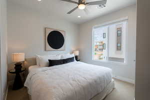 Bedroom with ceiling fan and light carpet