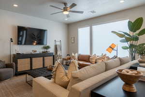 Living room featuring ceiling fan, wood-type flooring, and a textured ceiling