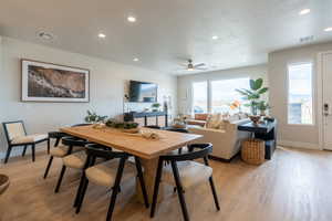 Dining space with light wood-type flooring, ceiling fan, and a textured ceiling