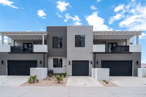 Modern home with a garage, cooling unit, and a balcony