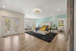 Bedroom with light hardwood / wood-style floors, crown molding, access to outside, and a textured ceiling