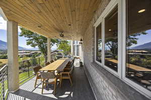 Wooden terrace featuring ceiling fan and a mountain view