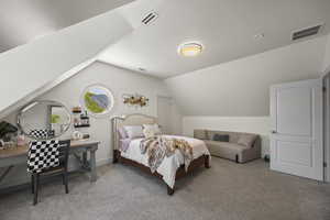 Carpeted bedroom with a textured ceiling and vaulted ceiling