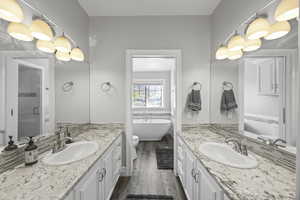 Bathroom with vanity, hardwood / wood-style floors, and shower with separate bathtub