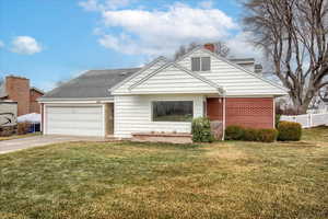 View of front of property featuring a front lawn and a garage