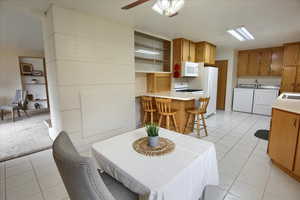 Carpeted dining area featuring washing machine and dryer and ceiling fan