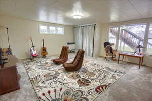 Living room featuring heating unit and light colored carpet