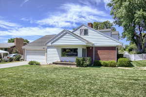 View of front of property featuring a front yard and a garage