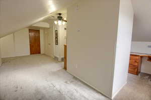 Bonus room featuring ceiling fan, light carpet, and lofted ceiling