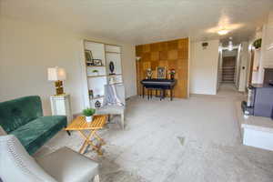 Sitting room featuring carpet and a textured ceiling