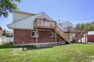 Rear view of property featuring a yard and a deck