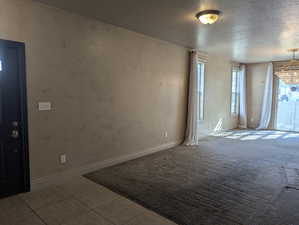 Unfurnished room featuring baseboards, carpet flooring, and a textured ceiling