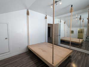 Bedroom with baseboards, vaulted ceiling, and wood finished floors