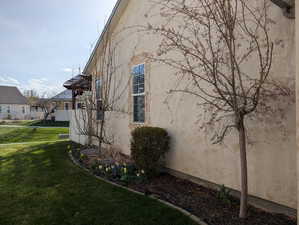 View of side of property with stucco siding and a lawn