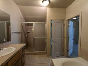 Primary Full bathroom featuring vanity, a stall shower, jetted tub, tile patterned flooring, and a textured ceiling