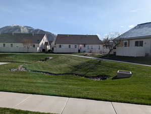 Exterior space with a mountain view, fence, and a lawn
