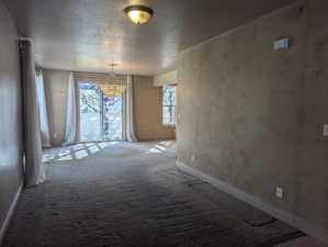 Unfurnished room with baseboards, carpet flooring, and a textured ceiling