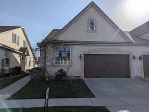 View of front of property with concrete driveway and stucco siding