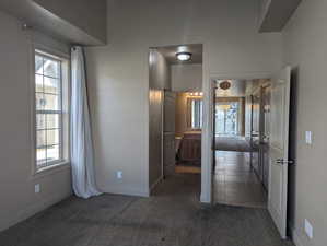 Hall with carpet flooring, baseboards, and plenty of natural light